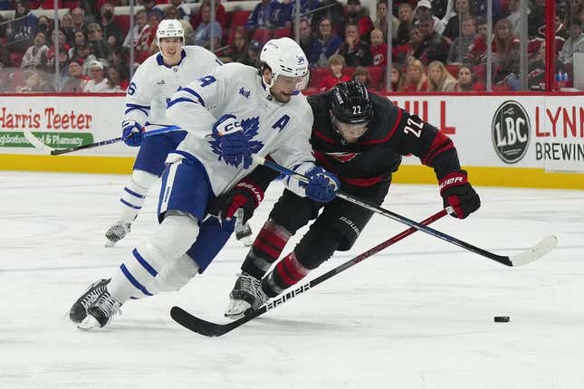 Mar 25, 2023; Raleigh, North Carolina, USA;  Toronto Maple Leafs center Auston Matthews (34) skates after the puck against Carolina Hurricanes defenseman Brett Pesce (22) during the second period at PNC Arena.