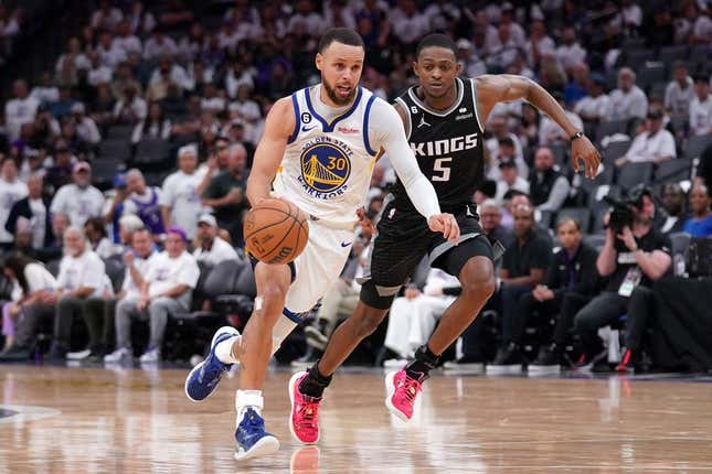 Apr 15, 2023; Sacramento, California, USA; Golden State Warriors guard Stephen Curry (30) dribbles past Sacramento Kings guard De&#39;Aaron Fox (5) in the third quarter during game one of the 2023 NBA playoffs at the Golden 1 Center.