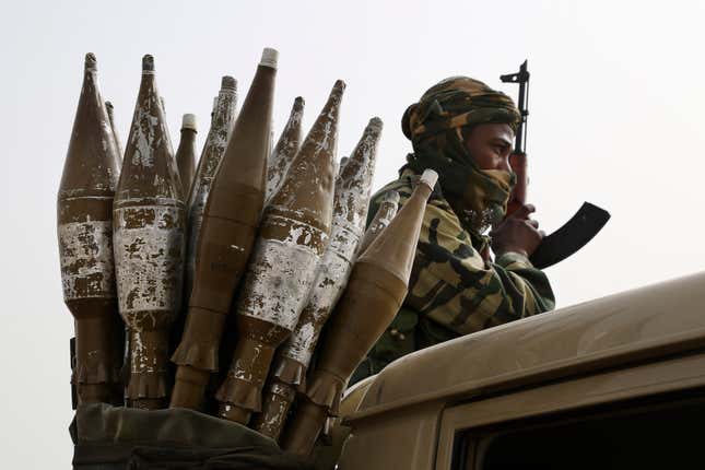 A Chadian soldier rides atop a pickup truck