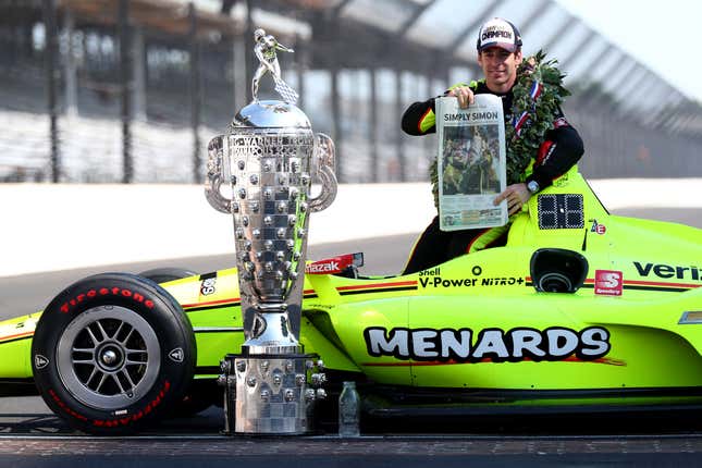 Simon Pagenaud poses with his 2019 Indy 500-winning car and the Borg-Warner Trophy