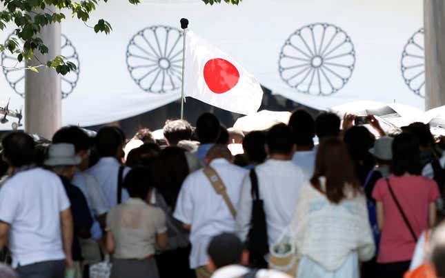 A Japan's national flag flutters among visitors at the Yasukuni Shrine in Tokyo August 15, 2014, on the 69th anniversary of Japan's surrender in World War Two. Japanese Prime Minister Shinzo Abe on Friday sent a ritual offering to the Tokyo shrine to war dead but did not join senior government officials in a visit, a decision meant to avoid inflaming ties with Beijing as he seeks a Sino-Japanese summit.