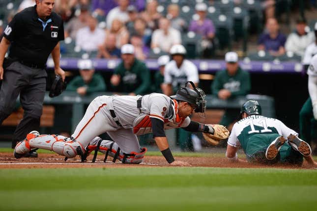 Jun 7, 2023; Denver, Colorado, USA; Colorado Rockies first baseman Mike Moustakas (11) slides safely home ahead of the tag from San Francisco Giants catcher Blake Sabol (2) in the second inning at Coors Field.