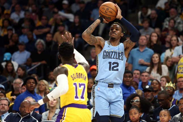 Apr 26, 2023; Memphis, Tennessee, USA; Memphis Grizzlies guard Ja Morant (12) shoots a three point shot as Los Angeles Lakers guard Dennis Schroder (17) defends during the second half of game five of the 2023 NBA playoffs at FedExForum.