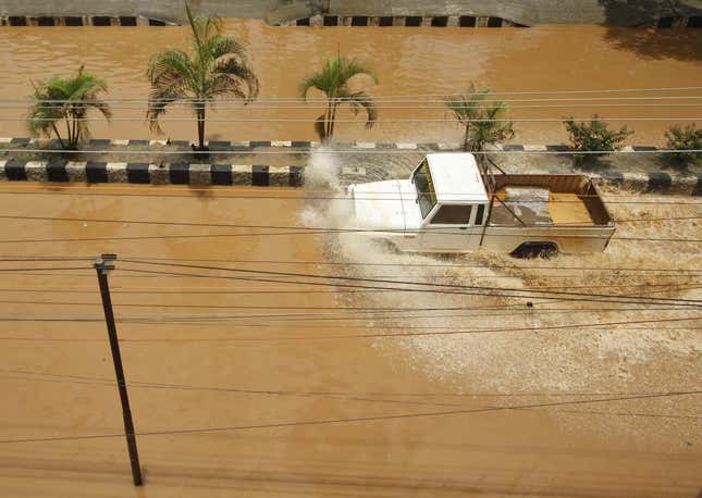 Vehicle moves through a flooded road after heavy rains at Guwahati