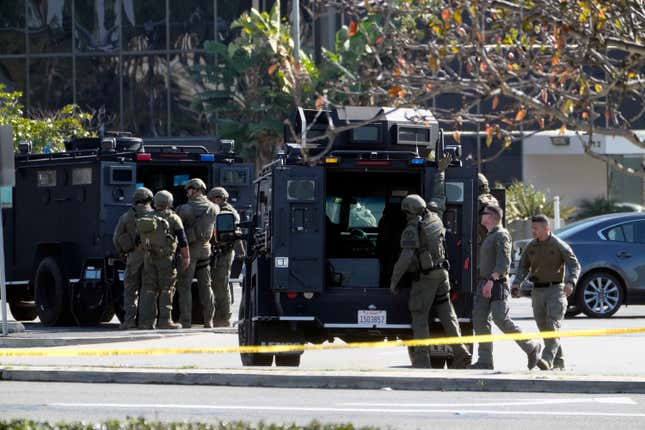 SWAT personnel surround a van, not seen, in Torrance Calif., Sunday, Jan. 22, 2023. A mass shooting took place at a dance club following a Lunar New Year celebration, setting off a manhunt for the suspect.