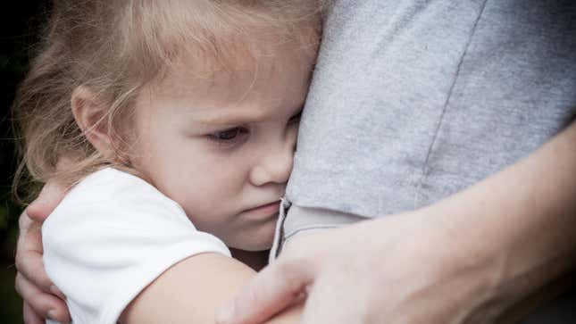 scared little girl hugging parent