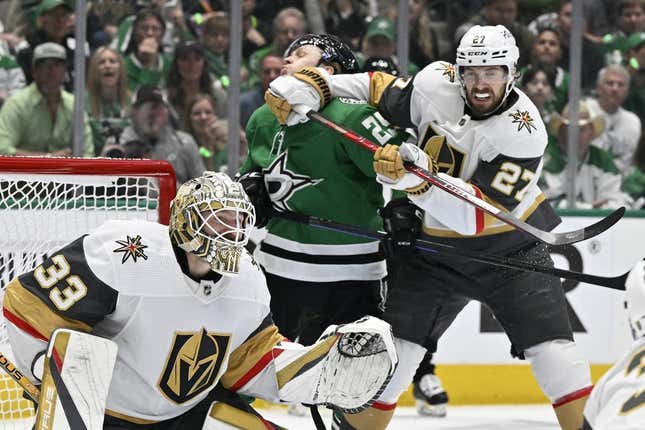 May 29, 2023;  Dallas, TX, USA;  Dallas Stars left winger Joel Kiviranta (25) is hit by the stick of Vegas Golden Knights defenseman Shea Theodore (27) as Kiviranta looks for the puck past goaltender Adin Hill (33) during of the first period of Game 6 of the Western Conference 2023 Stanley Cup Playoff Finals at American Airlines Center.