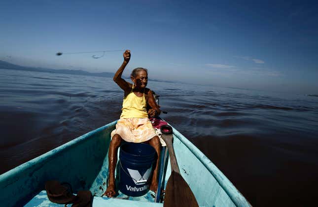 Cecilia Villegas, 77, throws a fishing line along the sea of the Pacific coast of Cano Ciego Island