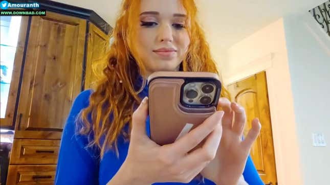 Amouranth smiles at her iPhone during a Kick stream.