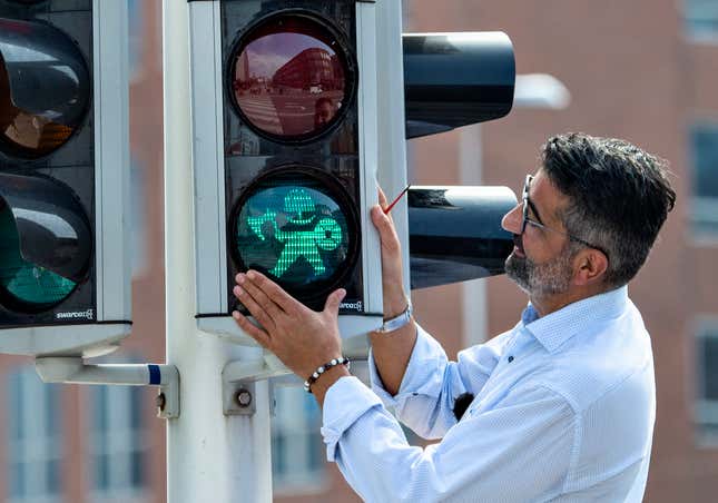 Aarhus city council member Bunyamin Simsek replaces the first of the many pedestrian signals with Vikings lights on Aug. 26, in Aarhus, Denmark.