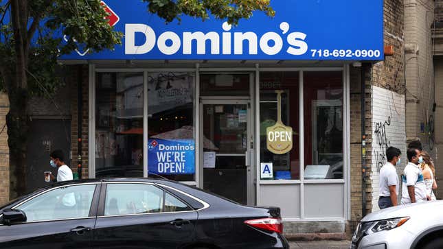  People walk past a Domino’s in Brooklyn, New York. Domino’s made an announcement on Tuesday that it is seeking to fill 20,000 positions at its corporate and franchise stores nationwide. 