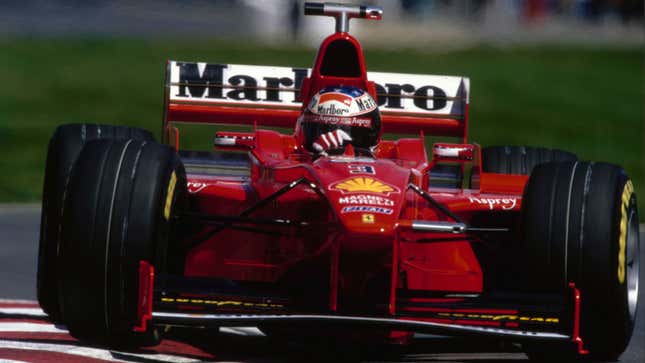 A photo of Michael Schumacher driving a red Ferrari F300 F1 car. 