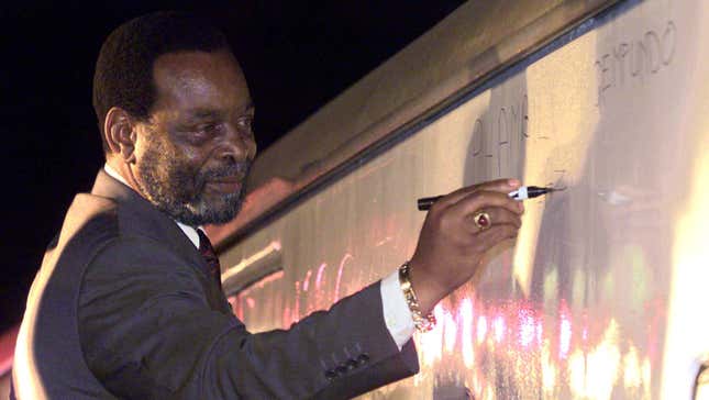 South Africa's Zulu King Goodwill Zwelithini signs a message on a train carriage in Zulu, "Phambili Ngemfundo" or "forward with education" at Durban station in 2000.