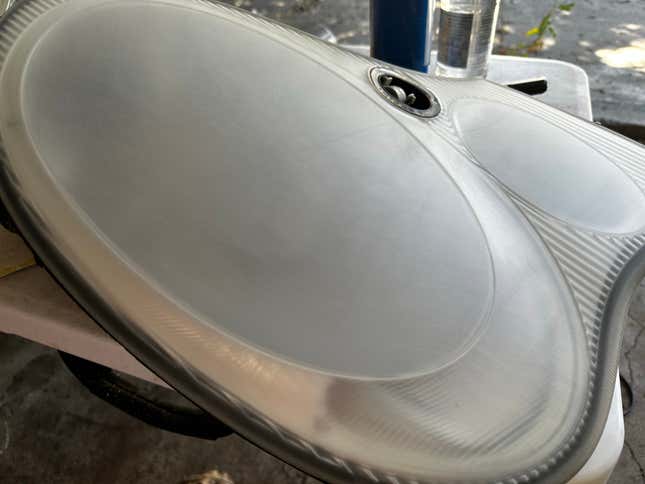 A sanded, hazy headlight is waiting to be painted.