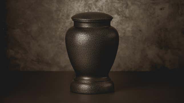 A dark-colored urn for cremation ashes sitting on a table