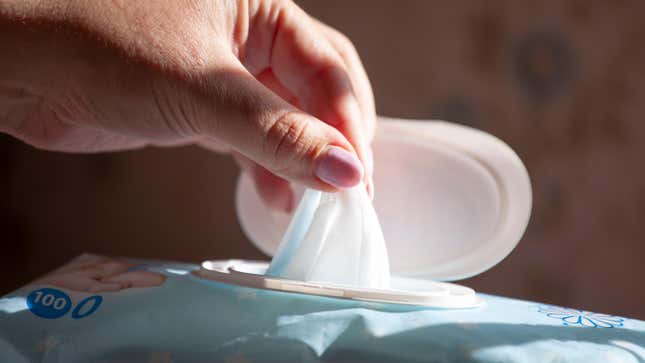 Closeup of hand pulling a wet wipe out of a package