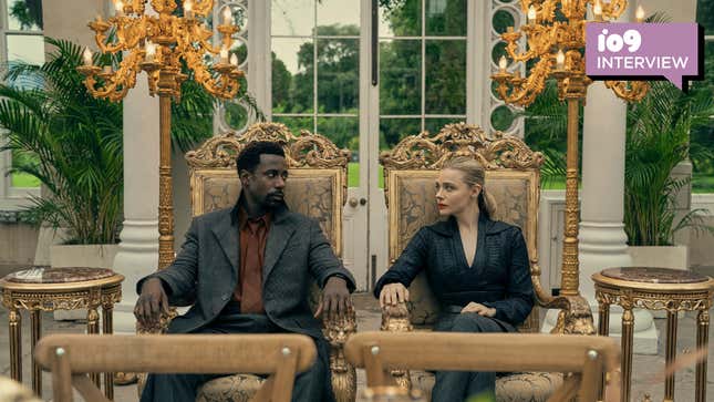 A man and a woman sit on ornate chairs in an opulant room.