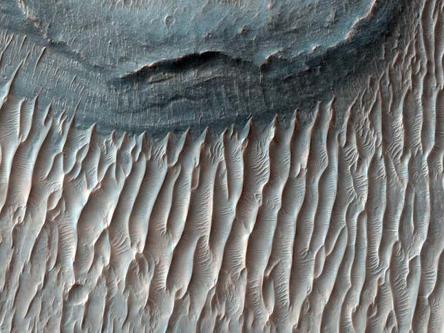 Ius Chasma shows signs of water and wind, which shaped these rock formations.