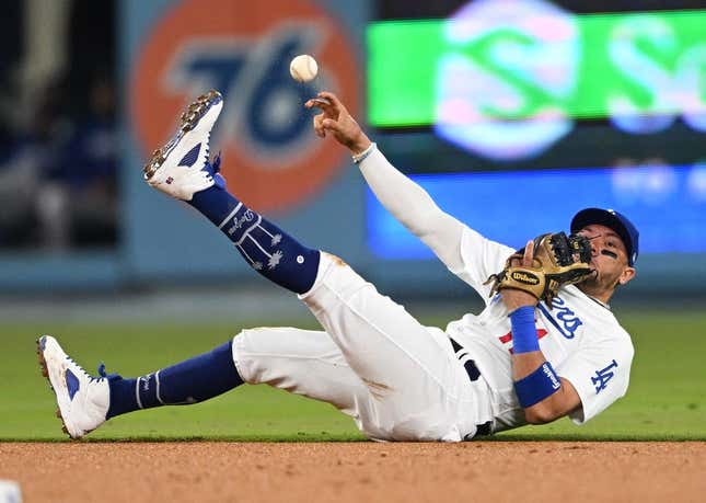 Apr 18, 2023; Los Angeles, California, USA; Los Angeles Dodgers shortstop Miguel Rojas (11) tries to make a play but can   t get New York Mets shortstop Francisco Lindor (12) out at first in the fourth ininng at Dodger Stadium.