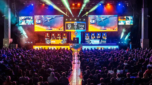 A picture of a crowd watching esport players compete in a Halo event on a large stage. 