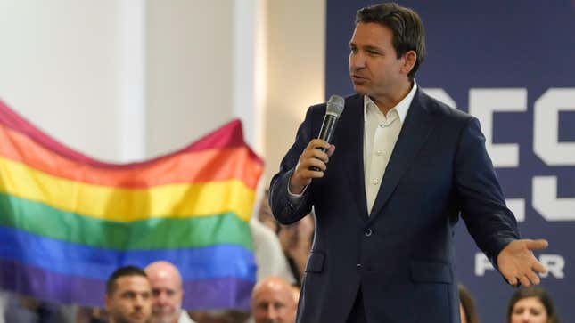 Protesters unfold and raise a rainbow flag behind Florida Gov. Ron DeSantis during the GOP presidential candidate’s campaign event on Monday, July 17, 2023, in Tega Cay, S.C.