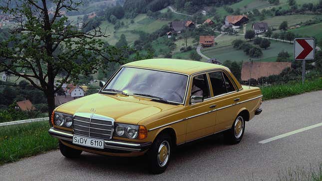 A yellow Mercedes sedan on a mountain road