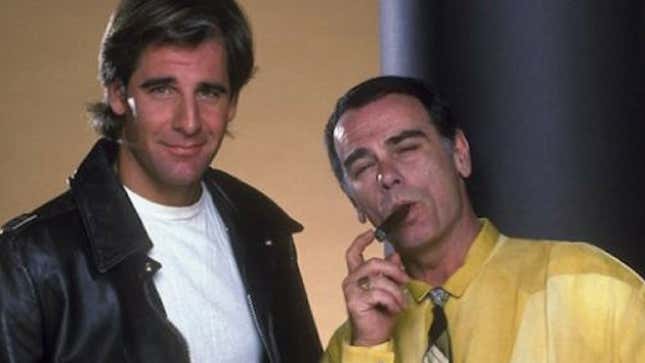 Scott Bakula wears a cool leather jacket and Dean Stockwell smokes a cigar while wearing a bright yellow dress shirt in a Quantum Leap publicity still.