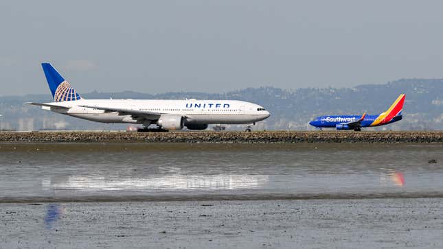 A United Airlines plane prepares for takeoff as an Southwest Airlines plane is landing at San Francisco International Airport (SFO) in San Francisco, California, United States on March 17, 2023.
