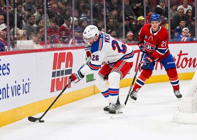 Mar 9, 2023; Montreal, Quebec, CAN; New York Rangers left wing Jimmy Vesey (26) plays the puck against Montreal Canadiens defenseman Kaiden Guhle (21) near the boards during the first period at Bell Centre.