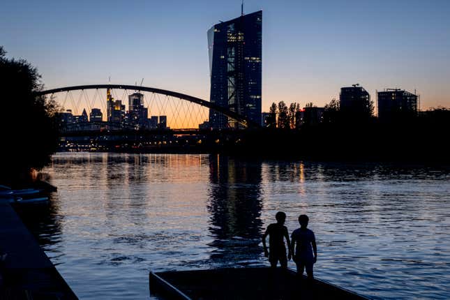 Two boys stand at the river Main near the European Central Bank in Frankfurt, Germany, after sunset on Friday, Sept. 8, 2023. (AP Photo/Michael Probst)
