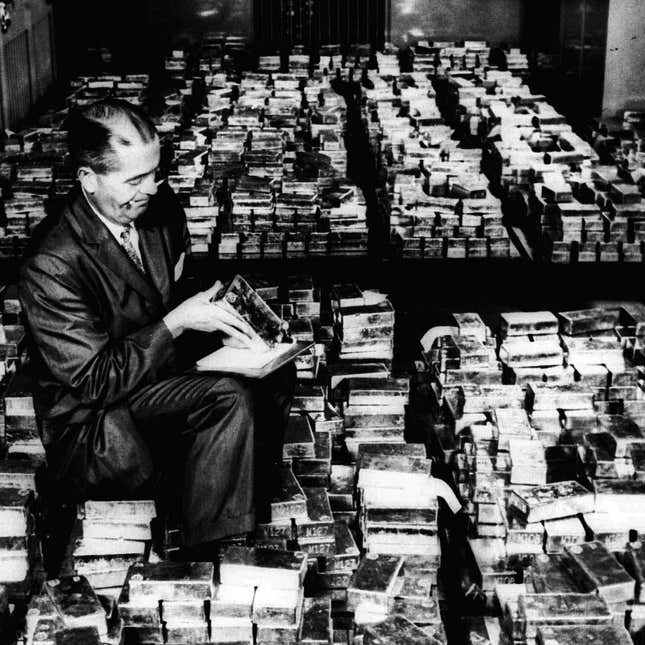 A member of the vault staff at the Federal Reserve Bank in New York inspects gold bricks in January 1965. at the Federal Reserve Bank in New York. Gold prices dropped Wednesday, Nov. 26, 1997, below $300 an ounce for the first time since 1985. Gold for December delivery fell $3.80 to $296.70 an ounce on the New York Mercantile, the second sharp drop in two days.