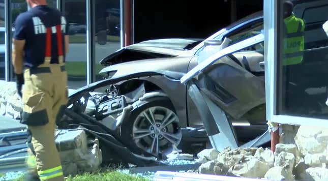 A crashed car sitting in debris after smashing through an Enterprise rental car location