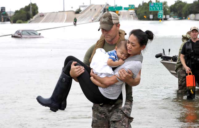 Houston Police SWAT officer Daryl Hudeck carries Catherine Pham and her 13-month-old son Aiden after rescuing them from their home surrounded by floodwaters from Tropical Storm Harvey on Aug. 27.