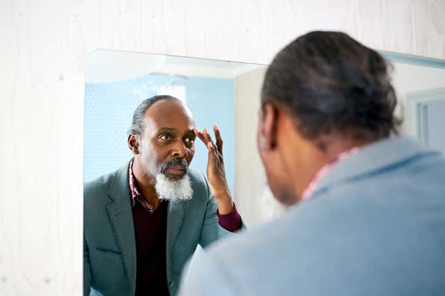 Black man looking in mirror 