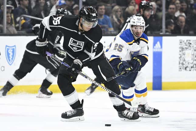 Mar 4, 2023; Los Angeles, California, USA; Los Angeles Kings center Quinton Byfield (55) moves the puck while pressured by St. Louis Blues center Jordan Kyrou (25) during the first period at Crypto.com Arena.