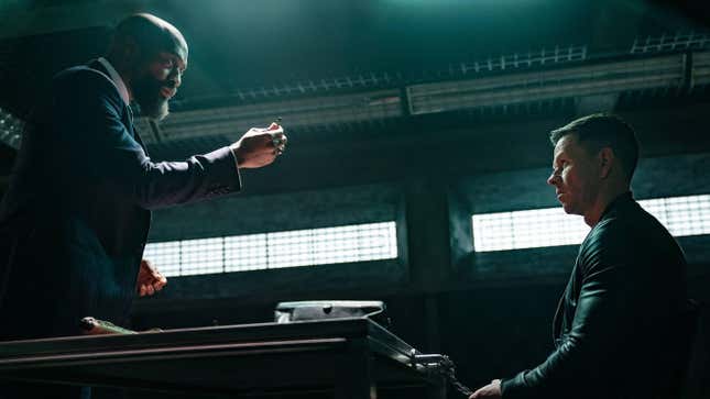 A standing, gesturing Chiwetel Ejiofor confronts a seated Mark Wahlberg in a scene from Infinite.