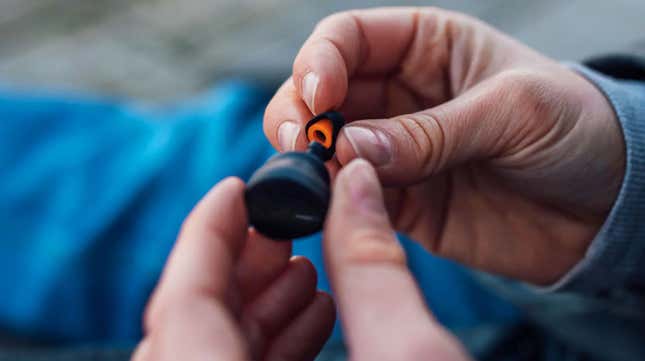Hands holding a Free Byrd earbud and a silicone tip