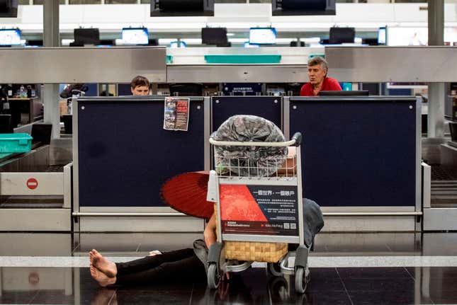 A traveler rests at a check-in counter at Hong Kong’s airport on Aug. 12, 2019.