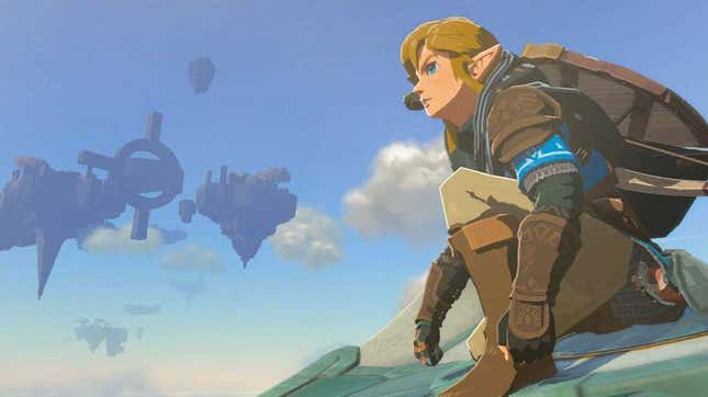 Link is seen crouching on a glider with sky islands visible in the distance.