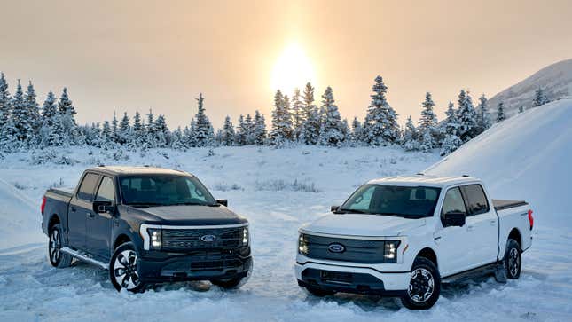 A photo of two electric Ford F-150 Lightning electric pickup rucks parked in snow. 