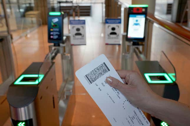 Person holding a boarding pass approaches facial recognition kiosk at the Hamburg, Germany, Airport. 