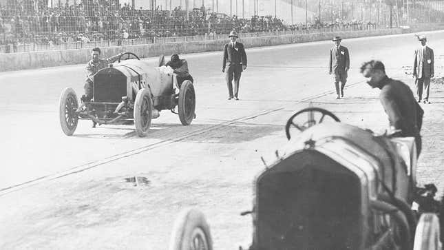Ralph DePalma (L) and his riding mechanic Rupert Jeffkins (R) pushing their Mecedes down the front straight