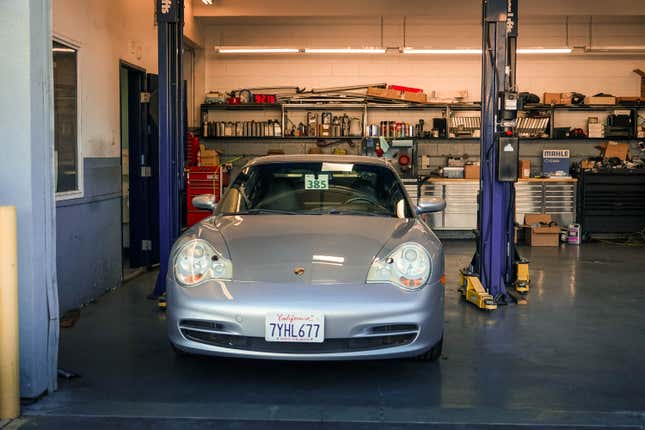 A silver 996 911 waits to go onto a car hoist for its pre-purchase inspection.