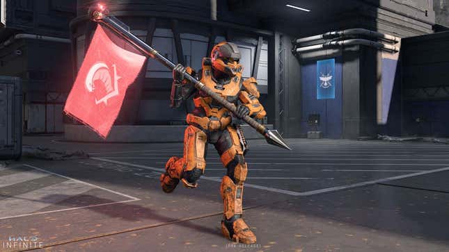 An orange spartan holds a red flag and runs on a steel floor in Halo Infinite multiplayer technical test