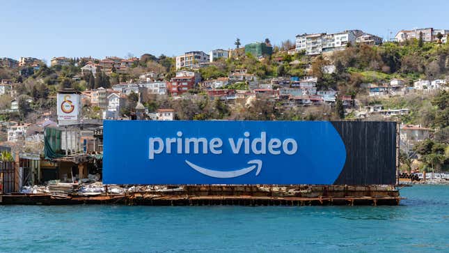 A picture of a Prime Video billboard next to the side of a coastal town with buildings rising up to the top of the bluff