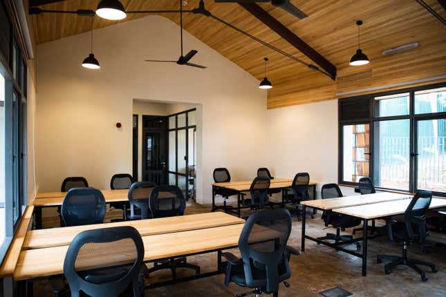 Brown desks and white tables in a room.
