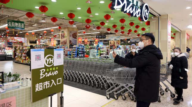A man scans his health code at the entrance of a supermarket on December 6, 2022 in Beijing,  China. 