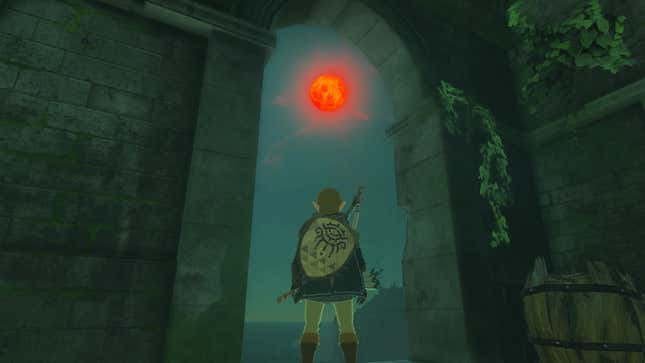 Link stands framed by a stone archway while a blood moon looms in the sky overhead.