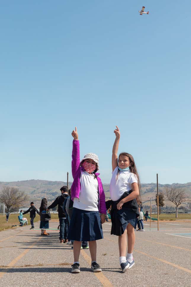 Holland, right, and a fellow Donald J. Meyer Elementary School student point out the airplane in the sky above them.