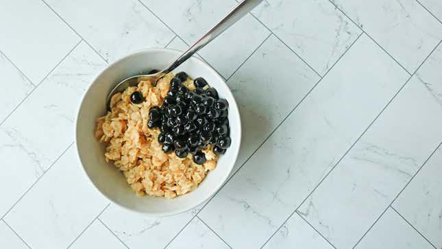 A bowl of oatmeal with a pile of black tapioca pearls on top.